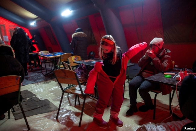 Ukrainasit ngrohen në një tendë në Kiev më 13 janar.