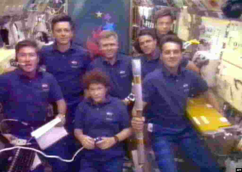 Space shuttle &quot;Columbia&quot; crew member Richard Linnehan (right) holds the Olympic torch in July 1996, the first relay tour into space.