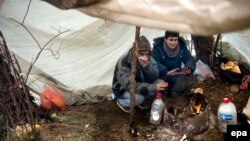 FILE: Afghan migrants sit in a tent at their temporary shelter in Subotica, northern Serbia.