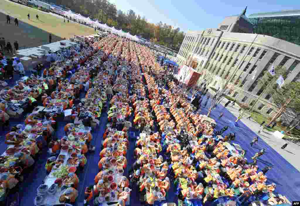 Some 2,000 South Korean volunteers make 140 tons of kimchi, a traditional Korean dish of spicy fermented cabbage and radish, in a park in Seoul. City officials will hand out kimchi to about 14,000 poor households in an event marking the start of the winter season. (AFP/Jung Yeon-Je)