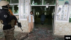 Сотрудник афганских сил безопасности на месте взрыва в центре Кабула. 3 февраля 2014 года.