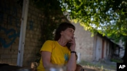 Olena Kanivec cigarettázik otthona előtt az ukrajnai Kupjanszk-Vuzlovijban 2023. augusztus 23-án