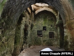 Small khachkars coated in moss embedded in the walls of an abandoned church near Dilijan. A pile of snow has formed under a hole in the roof of the church.