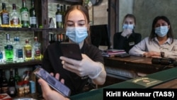 A visitor gets his QR code scanned before being allowed to patronize a restaurant in Novosibirsk on November 18.