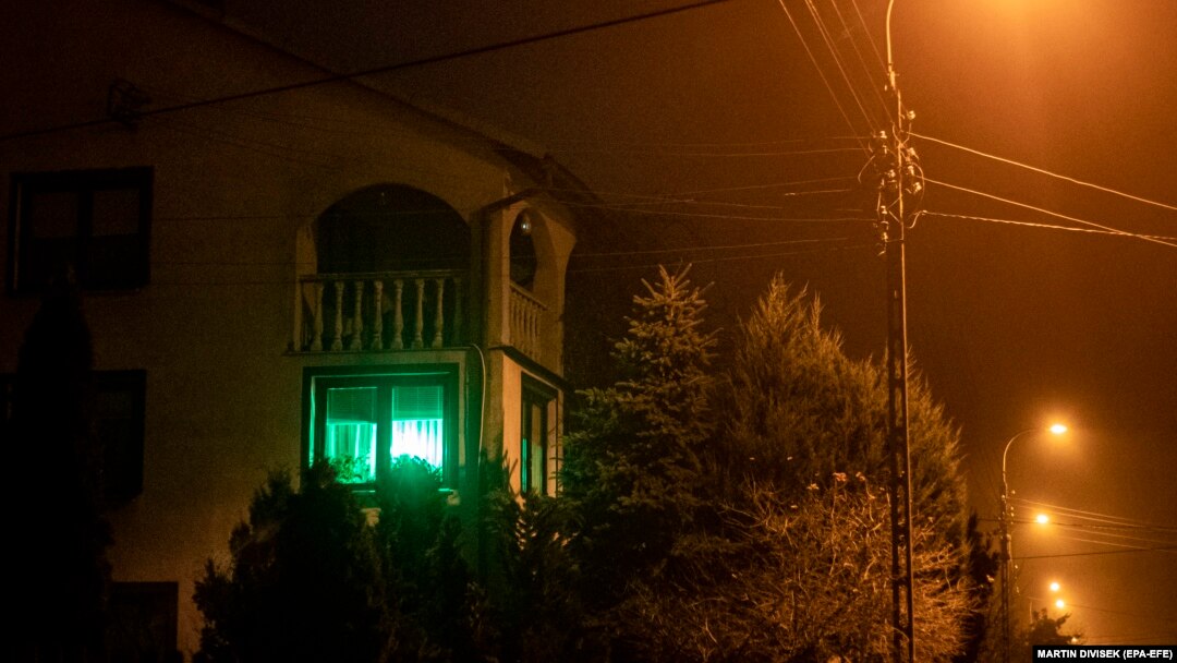 O lumină verde strălucește în fereastra unei case din orașul Michalowo, lângă granița polono-belarusă, unde o inițiativă încurajează locuitorii să „dea undă verde" dacă sunt dispuși să ajute migranții în căutare de hrană sau refugiu.