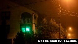 O lumină verde strălucește în fereastra unei case din orașul Michalowo, lângă granița polono-belarusă, unde o inițiativă încurajează locuitorii să „dea undă verde" dacă sunt dispuși să ajute migranții în căutare de hrană sau refugiu.