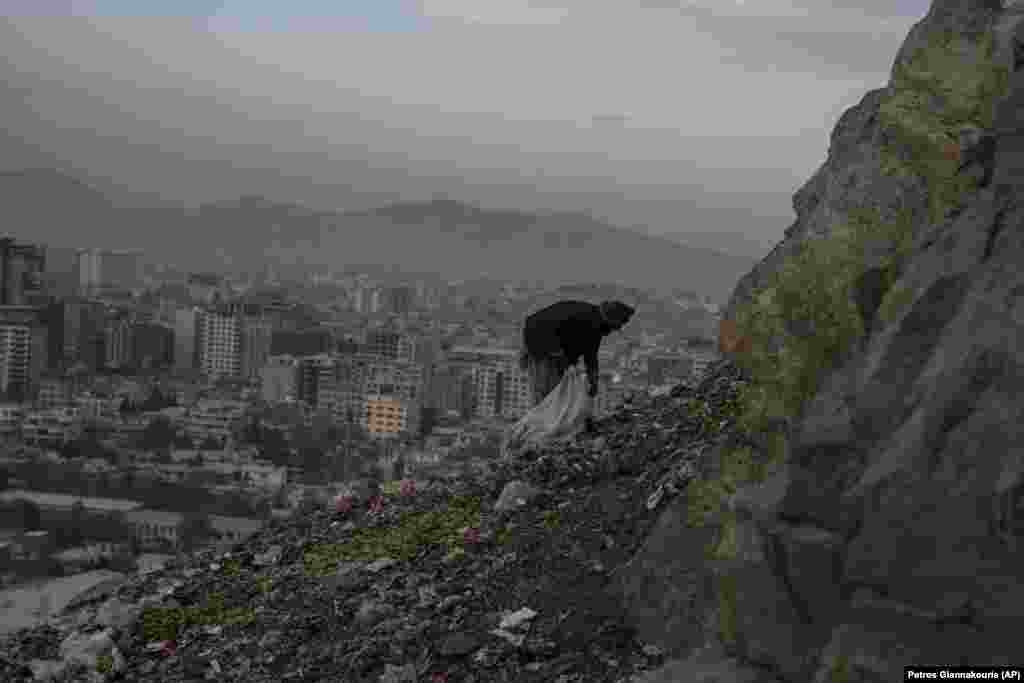 Un bărbat caută resturi de aluminiu și plastic pentru a le vinde, într-o groapă de gunoi din Kabul, Afganistan.