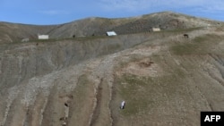 Afghanistan -- An Afghan villager walks on a hillslope near the scene in the landslide-hit Aab Bareek village in Argo district of Badakhshan, May 5, 2014