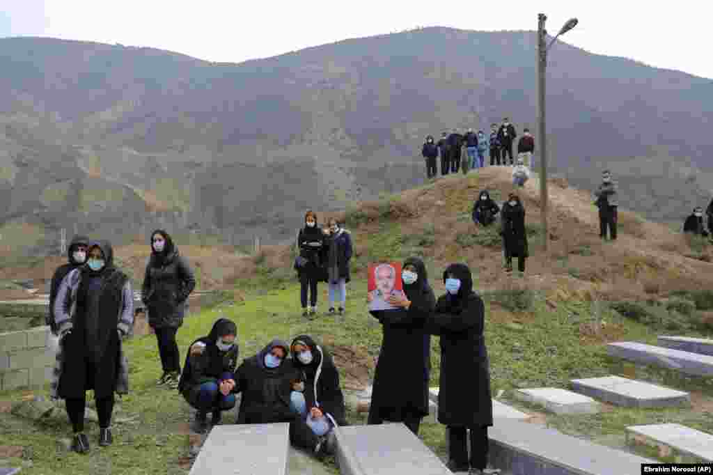 Mourners attend the funeral of a man who died from COVID-19 at a cemetery in the outskirts of the city of Ghaemshahr in northern Iran. (AP/Ebrahim Noroozi)