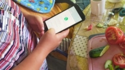 Мүмкіндігі шектеулі Оксана айтпақ болғанын смартфонға жазып, өзгелермен сөйлеседі. Тараз, 20 маусым 2020 жыл.