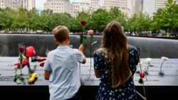 Deca stavljaju cveće pored uklesanih imena poginulih u Memorijalnom centru 11. septembar, tokom ceremonije obeležavanja 25. godišnjice napada na Svetski trgovinski centar, 11. septembar 2026.