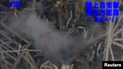 An aerial view shows smoke rising from the ruined roof of the No. 3 reactor at the Fukushima nuclear power plant.