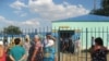 Родственники задержанных стоят у ворот Кенкиякского поселкового отделения полиции. Поселок Кенкияк Актюбинской области,1 июля 2011 года. 