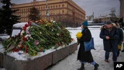 Një grua duke vendosur lule në nderim të Aleksei Navalnyt në monumentin për viktimat e shtypjes politike. Moskë, 17 shkurt 2024. 