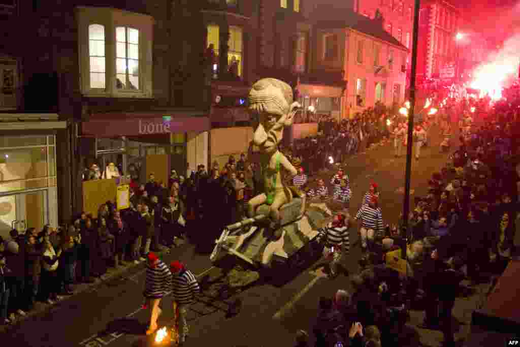 An effigy of Russian President Vladimir Putin is paraded through the streets of Lewes in Sussex, England, during traditional Bonfire Night celebrations. Bonfire Night is related to the ancient festival of Samhain, the Celtic New Year. (AFP/Justin Tallis)