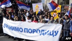 Protesters walk behind a banner reading "We Defend The Family" during a rally in the center of Belgrade on October 9 against a gay-pride parade planned for October 10.