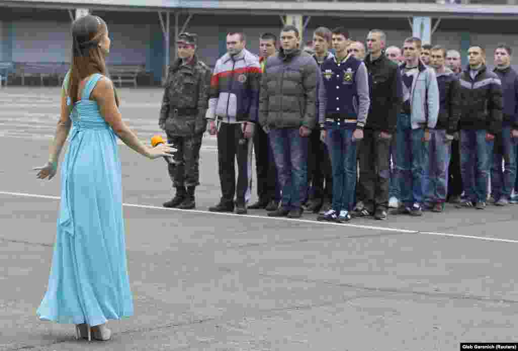 An artist performs as conscripts line up during a ceremony marking the last set of conscripts in the Ukrainian Army at the parade square in a recruitment office in Kyiv. (Reuters/Gleb Garanich)