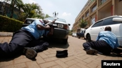 Kenyan police take cover outside the Westgate shopping center in Nairobi where gunmen from Somalia's Al-Qaeda-linked Al-Shabab movement went on a shooting spree on September 21.