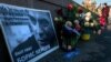 A woman passes by floral tributes at the site where opposition leader Boris Nemtsov was fatally shot on a bridge near the Kremlin in Moscow.