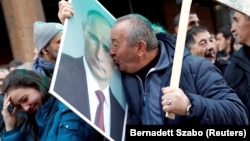 A supporter of Vladimir Putin kisses his portrait in Belgrade during the Russian president's visit to the Serbian capital on January 17.