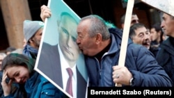 A supporter of Vladimir Putin kisses his portrait in Belgrade during the Russian president's visit to the Serbian capital on January 17. 