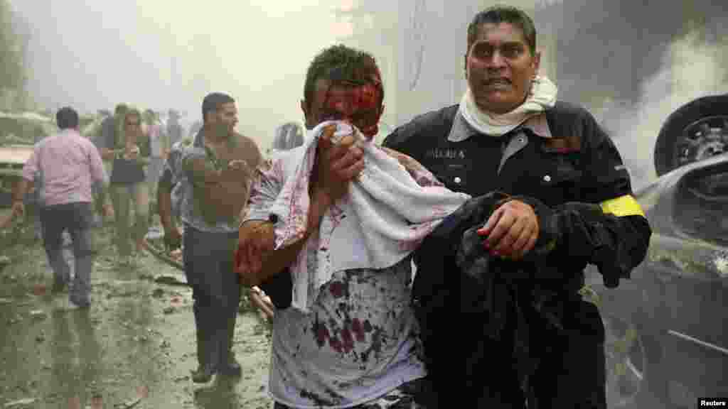 OCTOBER 19, 2012 -- A civil defense member helps a wounded man at the site of a car bombing in central Beirut. (Reuters/Hasan Shaaban)