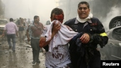 A Lebanese civil defence member helps a wounded man at the site of an explosion in Ashrafieh, central Beirut, on October 19.
