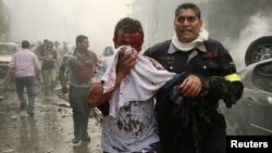 A Lebanese civil defence member helps a wounded man at the site of an explosion in Ashrafieh, central Beirut, on October 19. 