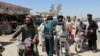 An Afghan policeman searches commuters at a checkpoint in Helmand on August 9.