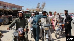 An Afghan policeman searches commuters at a checkpoint in Helmand on August 9.