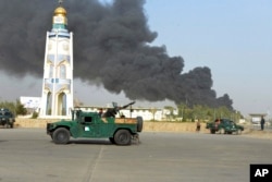 Afghan security forces arrive after a powerful explosion outside the provincial police headquarters in Kandahar Province last month. Talks have not led to any drop in Taliban attacks.