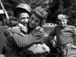 Російський солдат обіймає фотографа з 82-ї повітряно-десантної дивізії США, який був приєднаний до 2-ї британської армії, травень 1945 року, Грабов, Німеччина. Фотокопія знімка, зробленого на фотовиставці в Алмати