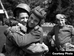Російський солдат обіймає фотографа з 82-ї повітряно-десантної дивізії США, який був приєднаний до 2-ї британської армії, травень 1945 року, Грабов, Німеччина. Фотокопія знімка, зробленого на фотовиставці в Алмати