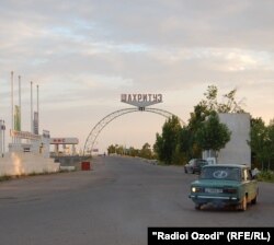 Указатель на въезде в Шахритус, засушливый район Таджикистана, известный своими высокими температурами, недалеко от границ страны с Афганистаном и Узбекистаном.