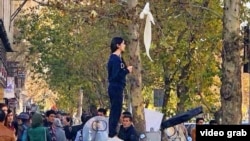 Iranian women have been removing their head scarves in public and waving them on sticks as a sign of protest.