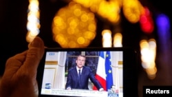 Новогоднее обращение президента Франции Эммануэля Макрона, транслируемое в Сети, на экране iPhone.