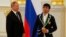 Russian President Vladimir Putin (left) and one of the country's Olympic gold-medal winners, judoka Beslan Mudranov, attend a ceremony for Russian Olympic medalists at the Kremlin on August 25.