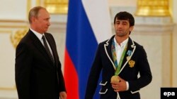 Rossiya prezidenti Vladimir Putin va Rioda oltin medalь olgan dzyudochi Mudranov Kremlda olimpiada g‘oliblarini taqdirlash marosimida, Moskva, 2016 yil 25 avgusti. 
