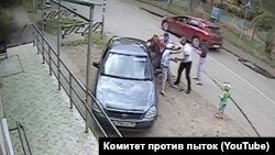 Полицейские силой пытаются посадить в машину Игоря Скоротягу и его мать. Скриншот из видео, опубликованного в ютуб-канале "Комитета против пыток"