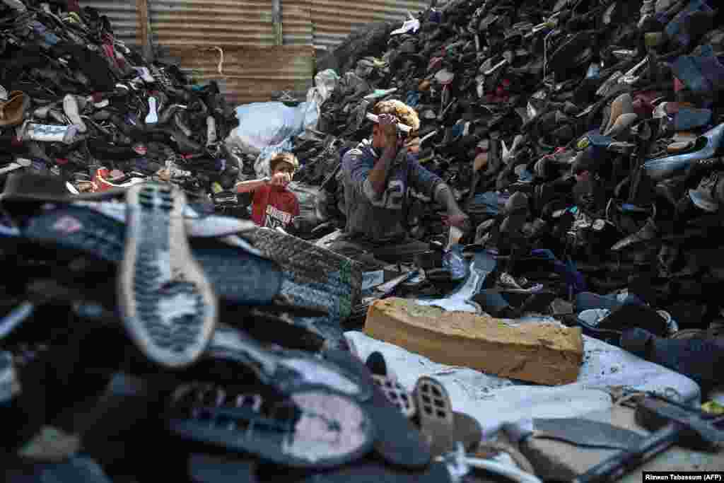 Laborers dismantle old shoes for recycling at a workshop in Karachi, Pakistan. (AFP/Rizwan Tabassum)