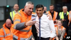 Rishi Sunak brit miniszterelnök, a Konzervatív Párt vezetője egy kampányrendezvényen közös fotót készít egy munkással az East Midlands-i Ilkestonban 2024. május 23-án