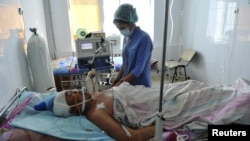 A nurse attends a man injured during deadly unrest in the town of Zhanaozen.