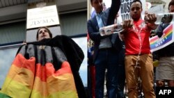 Protesting homophobia in Russia on two continents: an LGBT rights protester in Moscow (left) and one in New York.