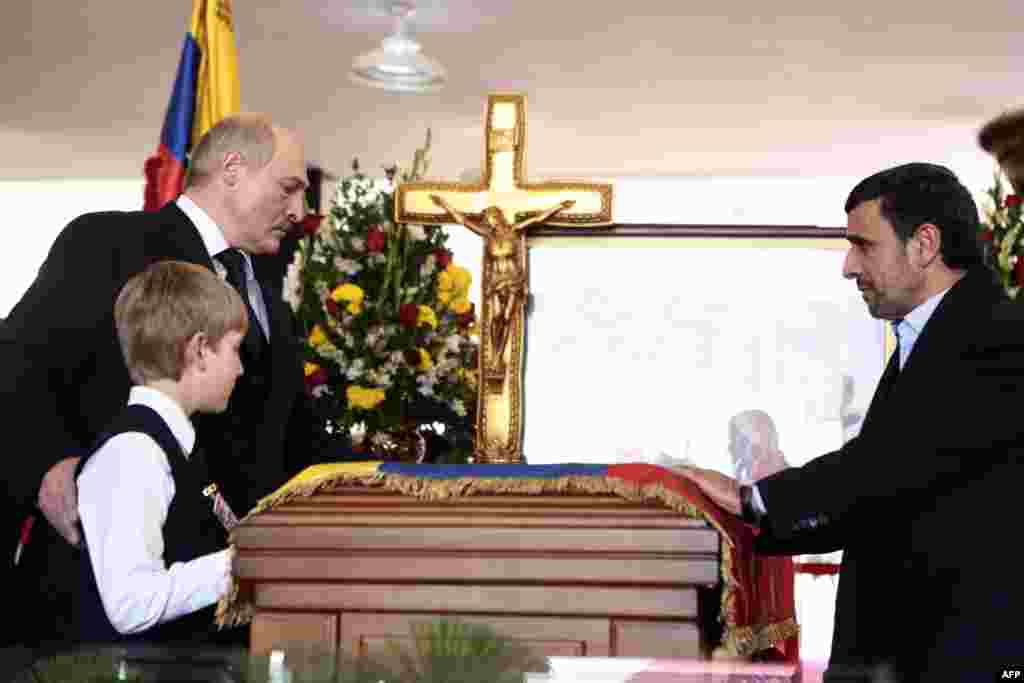 Iranian President Mahmud Ahmadinejad (right) and Belarusian President Alyaksandr Lukashenka and his son Nikolay pay their respects at the coffin of the late Venezuelan President Hugo Chavez in Caracas. (AFP/Presidencia/Miguel Angel Angul)