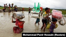 A Rohingya refugee woman falls as she walks through the water after crossing the border in Teknaf, Bangladesh, on September 1, 2017. Picture taken September 1.