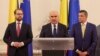 Liderii celor mai mari partide din Coaliția de guvernare: în centrul – premierul Ilie Bolojan (PNL), în dreapta liderul PSD Sorin Grindeanu, iar în stânga cel al USR, Dominic Fritz. 