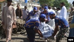 Pakistani rescue workers carry a body of a victim at the scene of a suicide bomb blast in Quetta, June 23, 2017