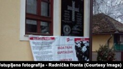 Spomen-ploča HOS-a s natpisom "Za dom spremni" u Jasenovcu, ispod protestni plakat Radničke fronte