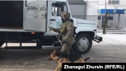 Конвоир и служебная собака у автозака рядом с колонией в Актюбинской области