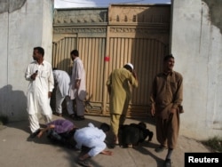 Local residents try to look past the gates into the compound where Al Qaeda leader Osama bin Laden was killed in Abbottabad in May 2011. (file photo)